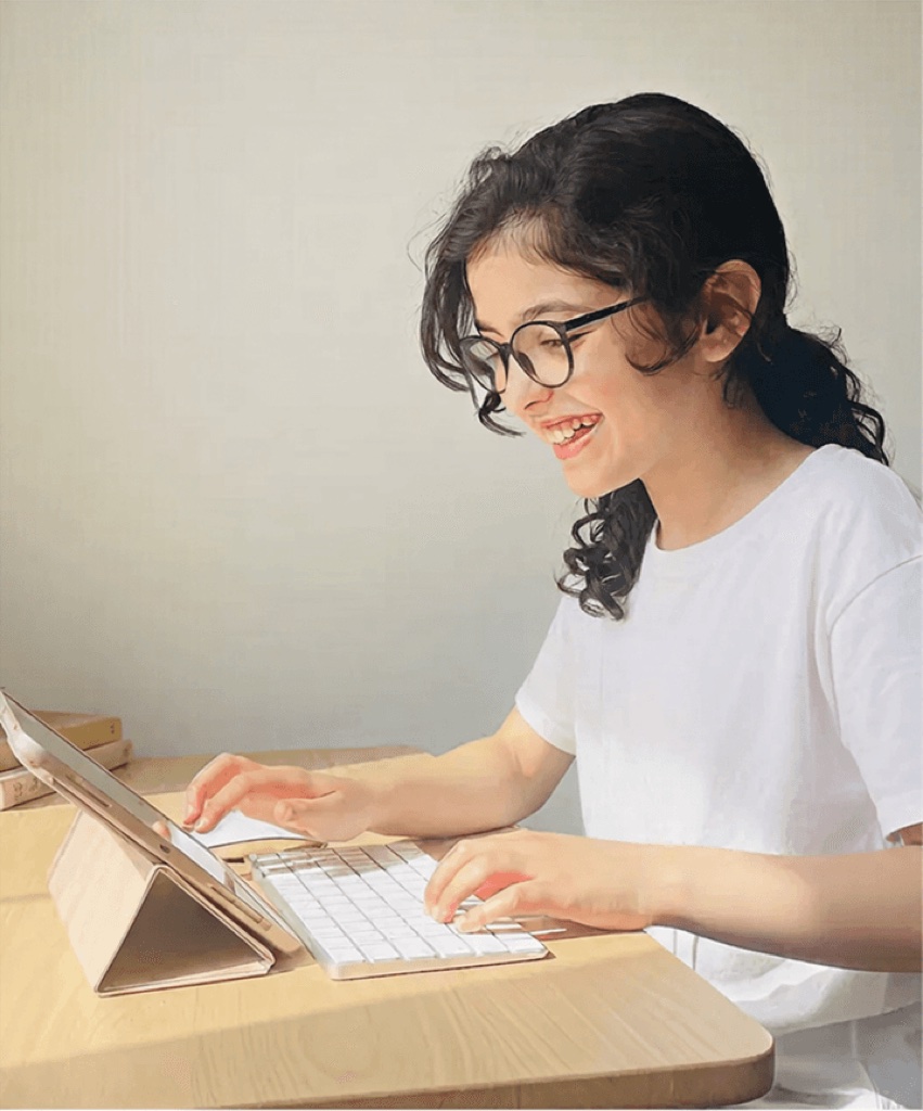 A team member smiling while typing on a laptop